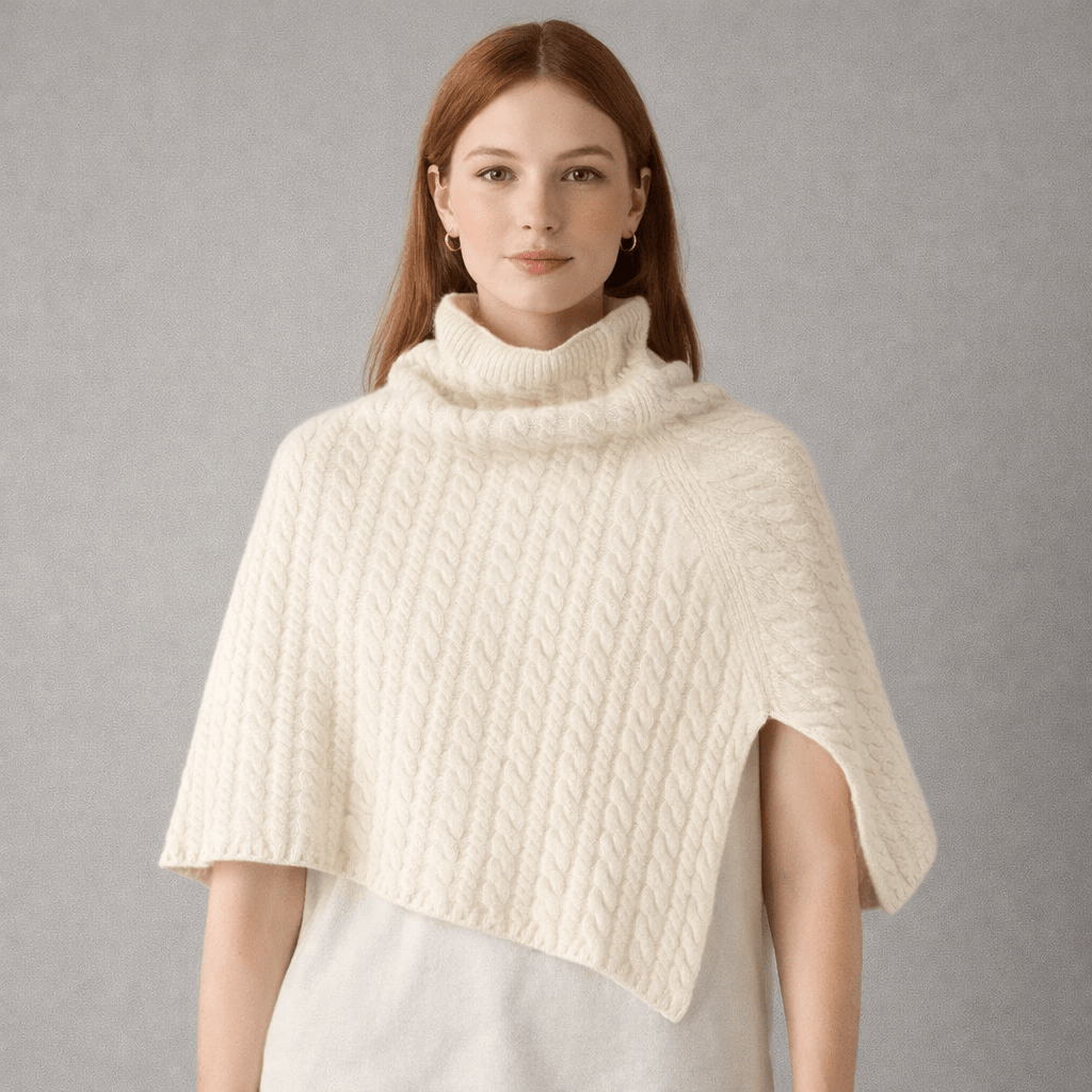 Model wearing a cream coloured cable knit  merino wool poncho 