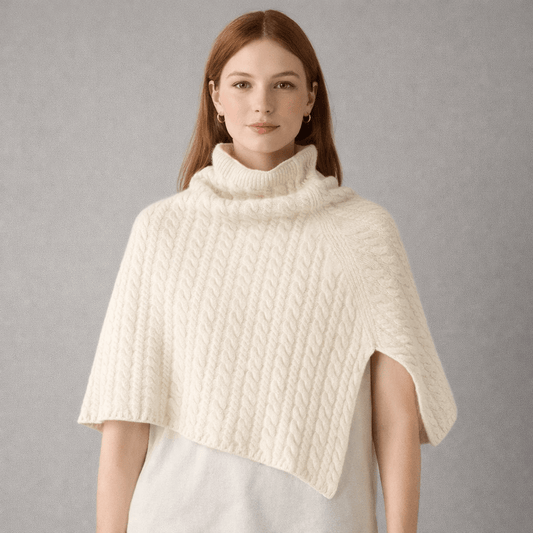 Model wearing a cream coloured cable knit  merino wool poncho 