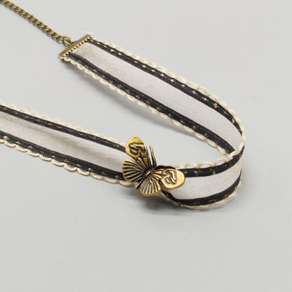 Ivory organza ribbon choker with antique bronze butterfly charm, product flat lay