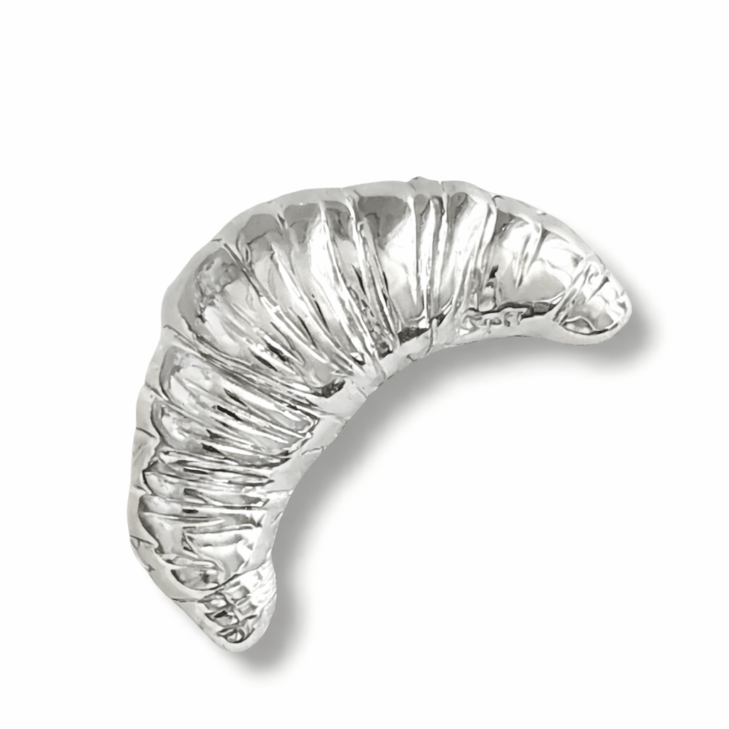 Silver crescent croissant brooch on a white background, vintage style