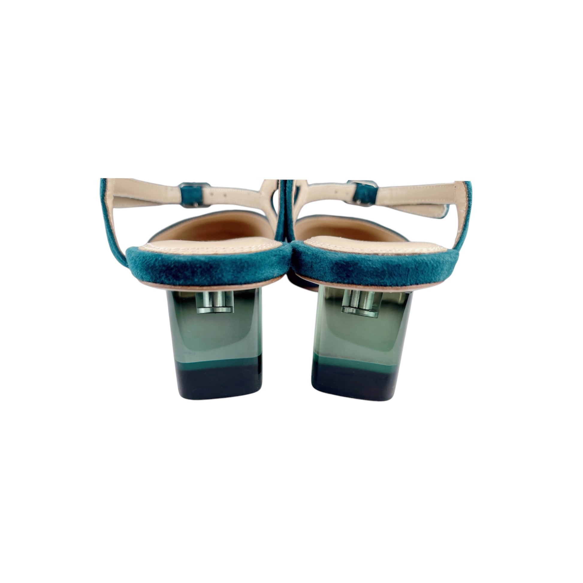 Close-up of coloured crystal Perspex heel on green suede vintage pumps