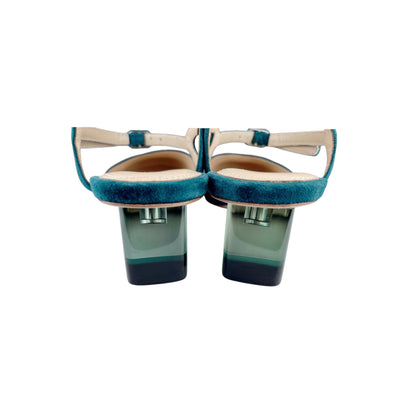 Close-up of coloured crystal Perspex heel on green suede vintage pumps