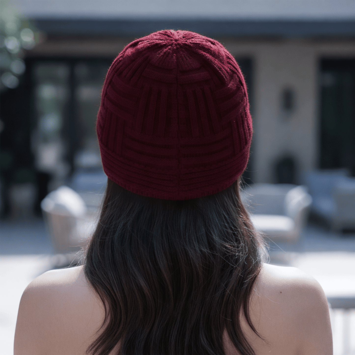 Woman wearing a Dark red chunky knit beanie from a back view